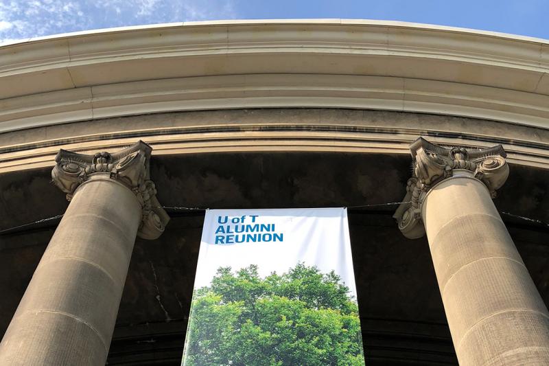 A banner reading "U of T Alumni Reunion" hangs between pillars outside Convocation Hall. (photo by Kimberly Lyn) 