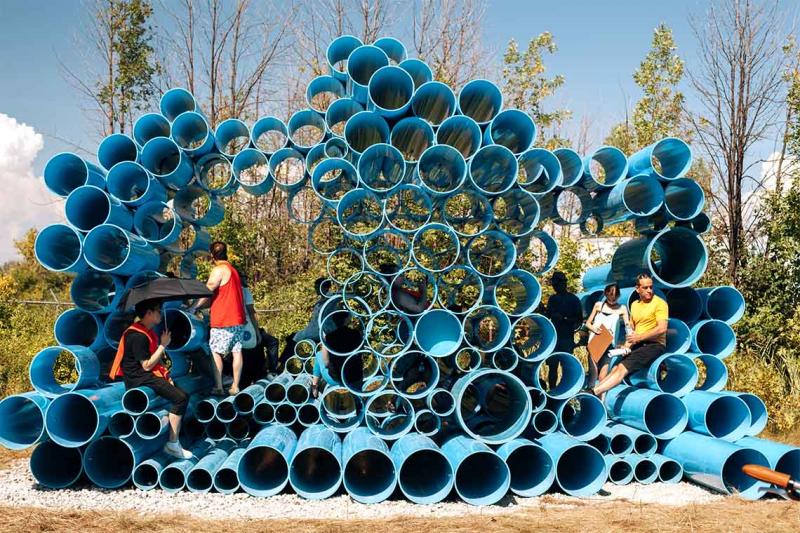 Visitors climb on the Futurity Island sonic artwork - dozens of massive water pipes piled three metres high like a 3D pan pipe.