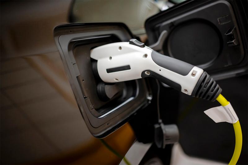 A charging cable is plugged into an electric car. (photo by Vitpho via Getty Images) 