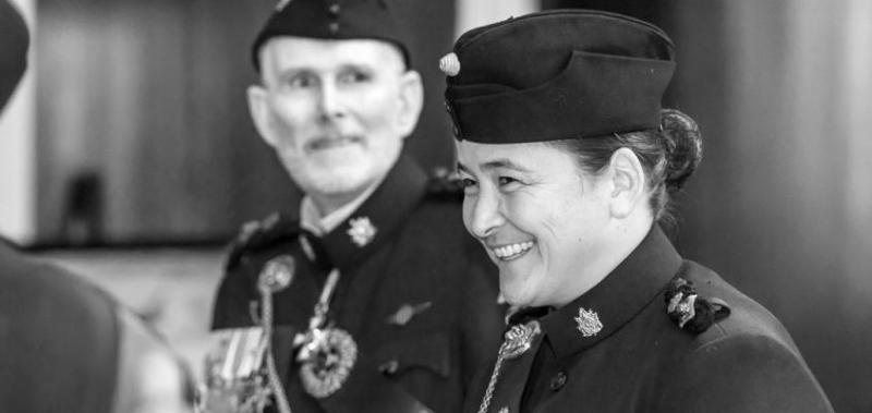 Vicky Sunohara smiles while wear a military hat and uniform with insignia on the collar.