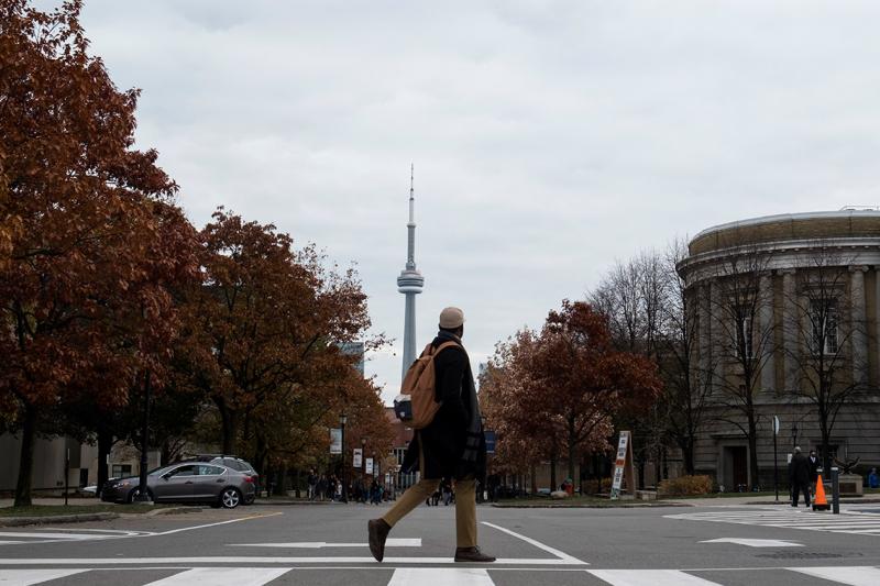 Student crossing Convocation Plaza in front of the CN Tower. Photo by Laura Pedersen