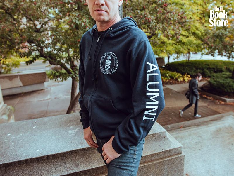 man wearing a dark blue, long sleeved t-shit with the U of T crest on the chest and "Alumni" written on the sleeve