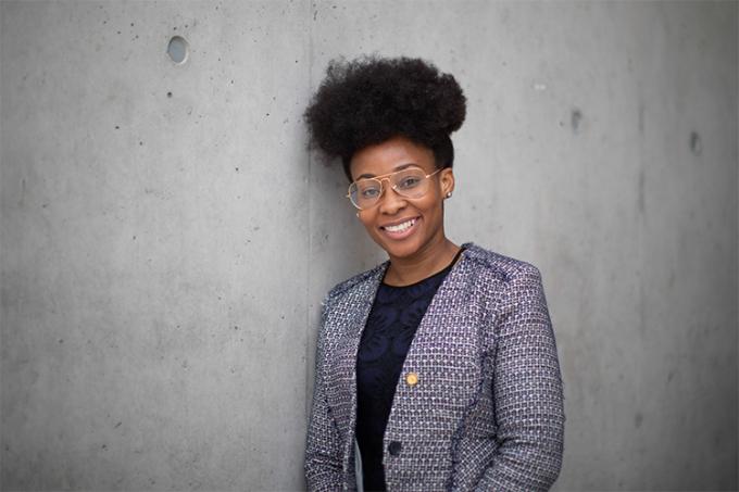 Mama Adobea Nii Owoo smiles while standing by a wall, indoors. (photo by Nick Iwanyshyn)