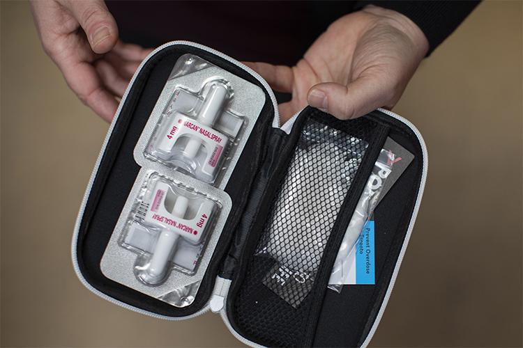The naloxone kit, zipped open, contains two blister-packed nasal sprays