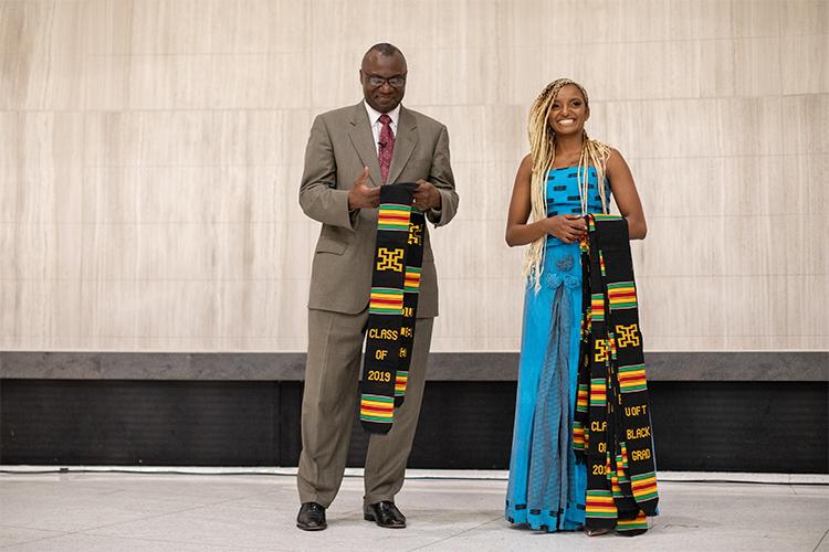 Wisdom Tette and Kalkidan Alemayehu hold scarves in traditional African colours that read "Class of 2019, U of T Black Grad".