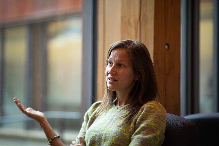 Clémentine Van Effenterre gestures while speaking in a chair by a window.