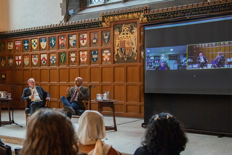 Margaret Atwood, talking to students via video call, appears on a screen in Hart House Great Hall.