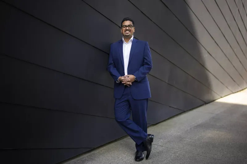 Amit Dalaya standing in front of a grey wall