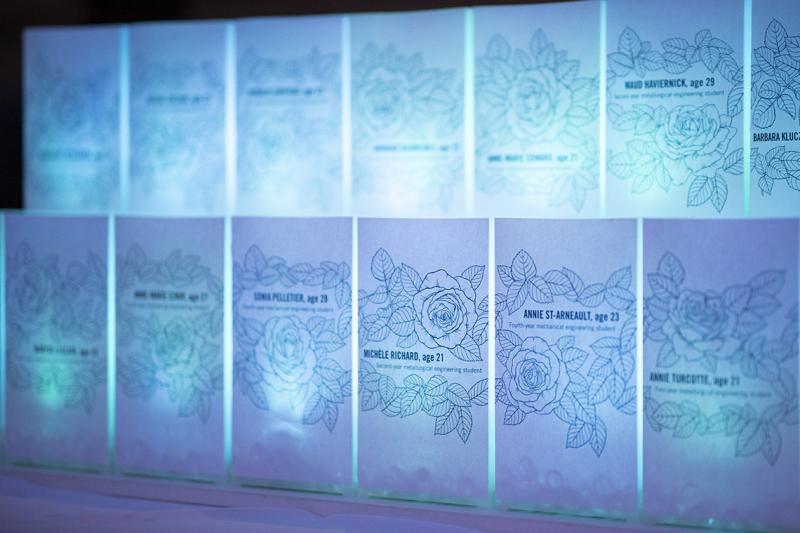 14 large cards, lit from behind, show the names and ages of the murdered women framed with a drawing of roses.