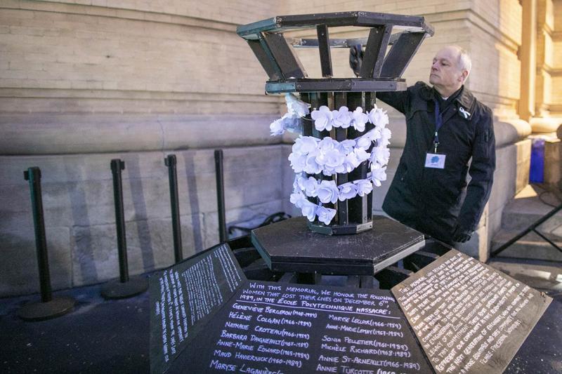 Meric Gertler lifts a flashlight into a large metal container hung with paper flowers and lists of murdered women.