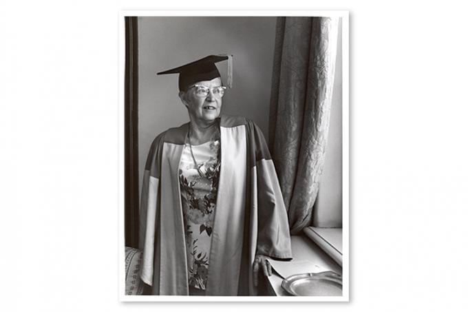 Photo of Elsie MacGill wearing academic robes and mortarboard and looking out a window.