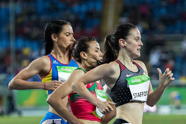 Gabriela DeBues-Stafford takes the lead in this close-up image of three women racing around a stadium track.