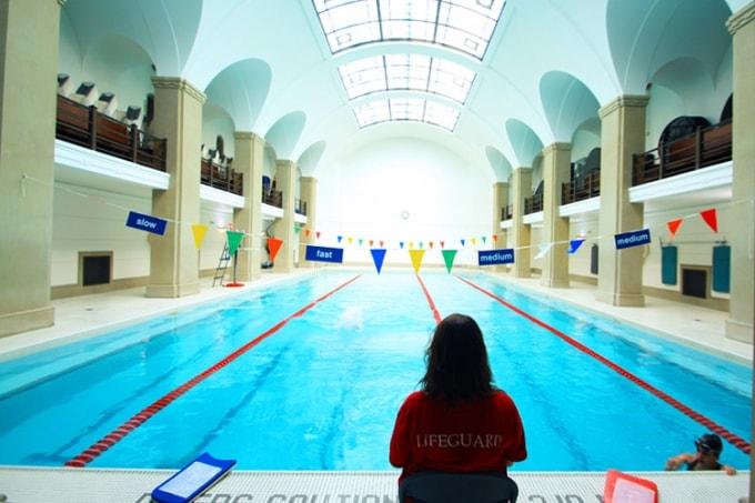 A lifeguard looks up at the skylights above the Hart House pool. (photo by Hart House)