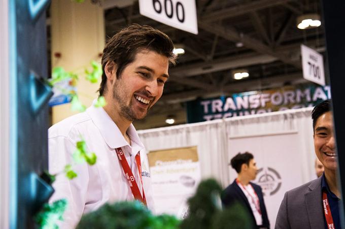 Conner Tidd chats with conference-goers about Just Vertical's new hydroponic towers at OCE Discovery (photo by Chris Sorensen)