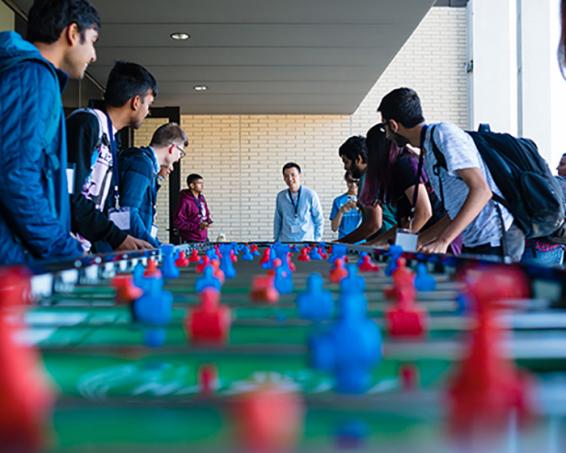 Guests and students network over a game of foosball at U of T's new Myhal Centre for Engineering Innovation & Entrepreneurship. Photo by Neil Ta.