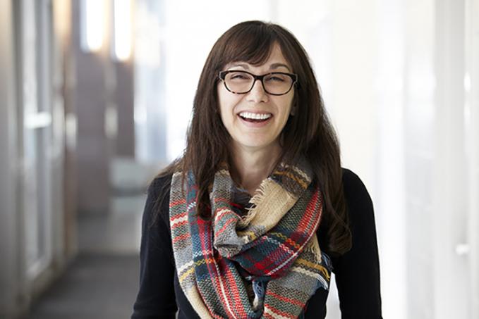 Picture of Chelsea Rochman laughing in a hallway indoors.