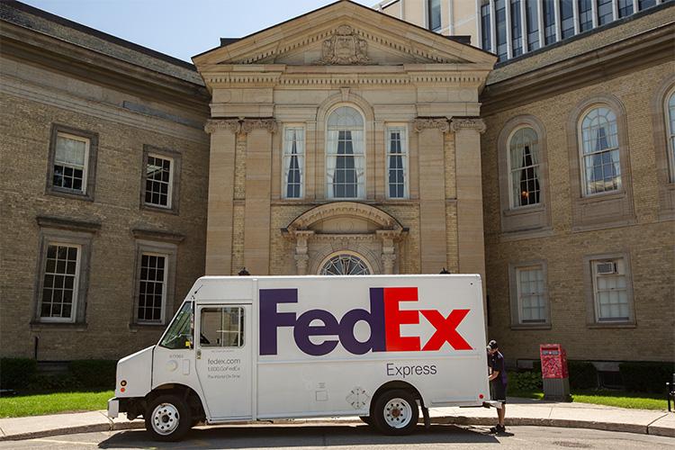 A van with the words FedEx on the side sits in front of U of T's Simcoe Hall.