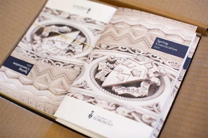 A stack of booklets, each with the words Spring Convocation 2020 on the cover over a picture of a carved stone crest.