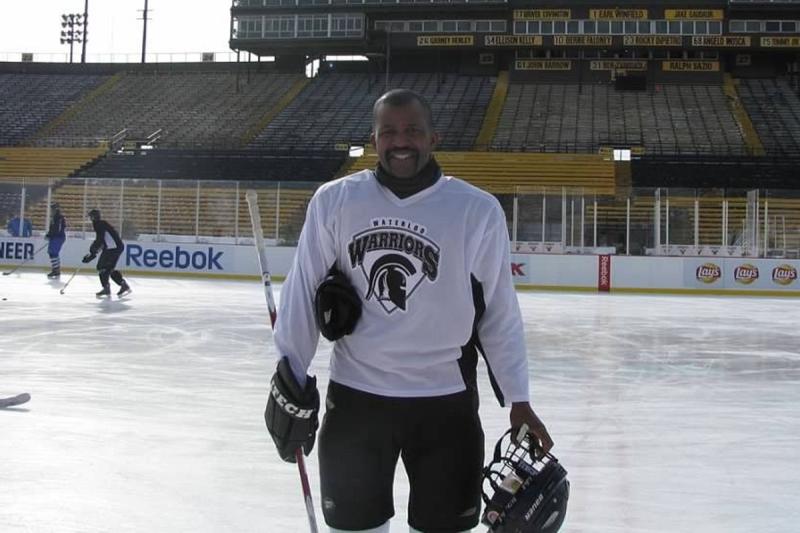 Dean Barnes, in a Waterloo Warriors hockey uniform, smiles as he poses on an outdoor ice rink.