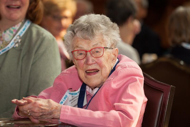 Alumna Nora Robinson smiling and sitting at a table