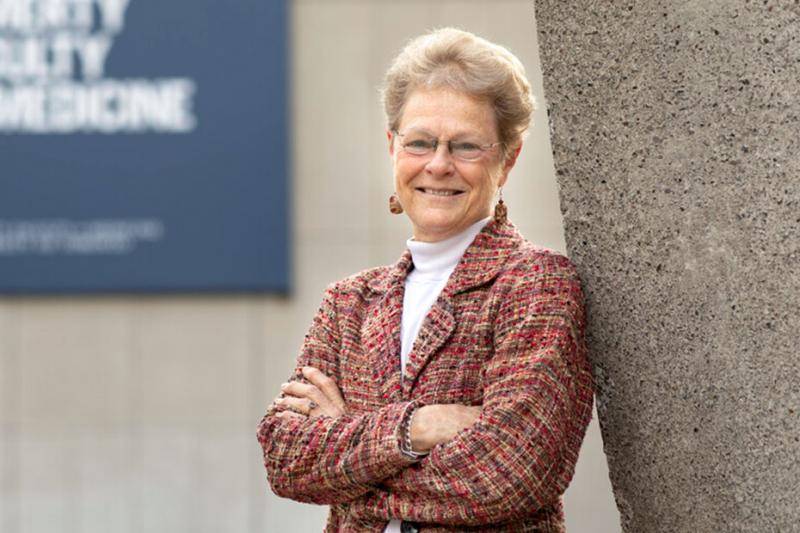 Photo of Patricia Brubaker smiling next to a tree