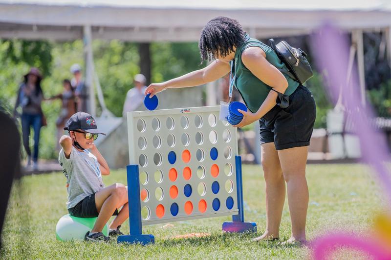 Mother and son playing connect four together at Alumni Fest.