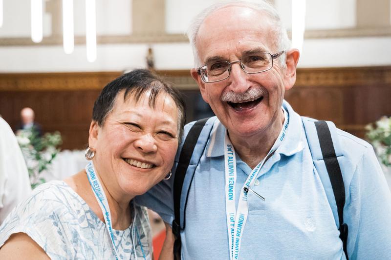 Alumni smiling together at the camera on anniversary event.