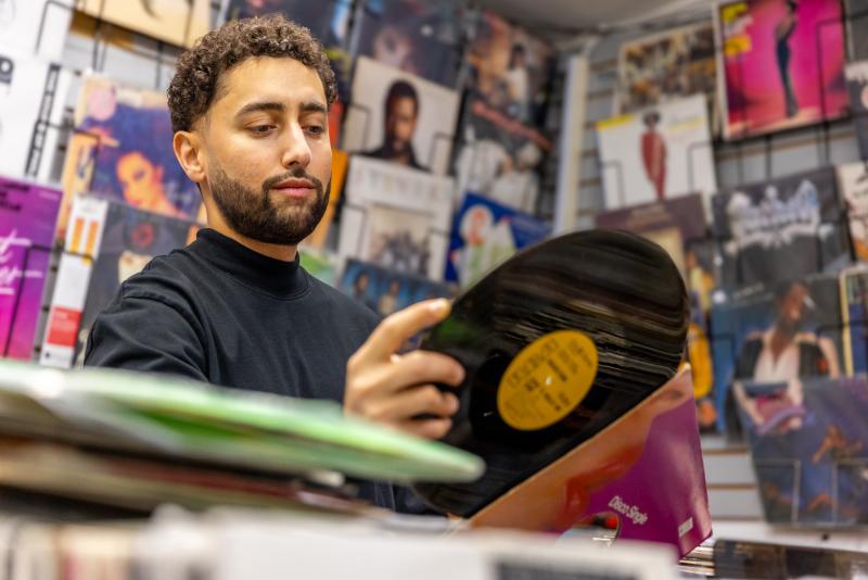 Amir putting a record back in its sleeve