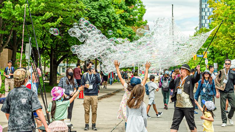 Photo of family playing together with bubbles in Alumni Fest East. 