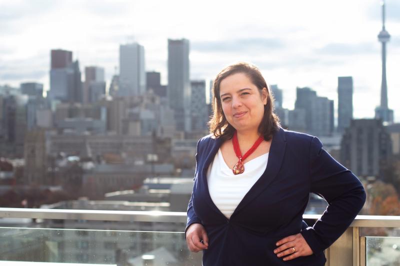 Anna Shternis stands onn a balcony overlooking U of T's Front Campus and downtown Toronto.