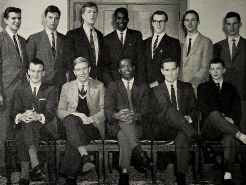 12 young men in suits and ties smile in a 1960s group photo. 2 are Black and 10 are white.