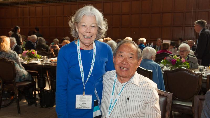 Two alumni smiling together at Chancellor's Breakfast.