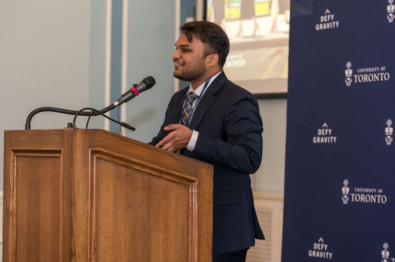 Akshit Goyal speaks at a podium.