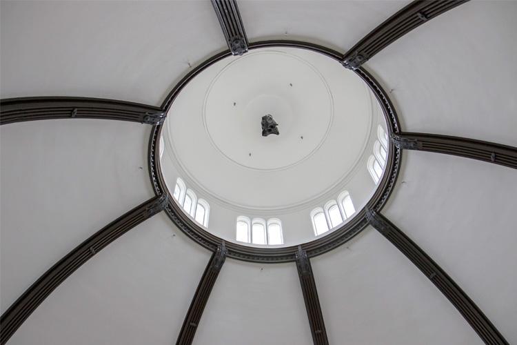 A view looking up at the ceiling of Croft Chapter House, showing the white-painted walls between ribs of dark wood.