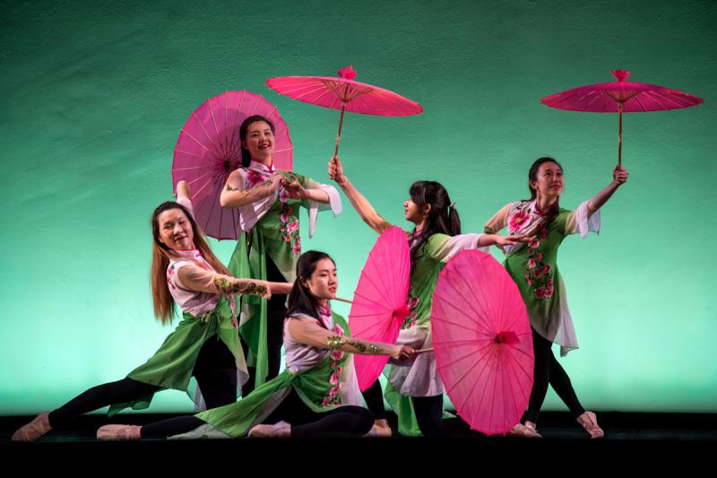 Five ballet dancers in traditional Asian costumes pose with parasols.