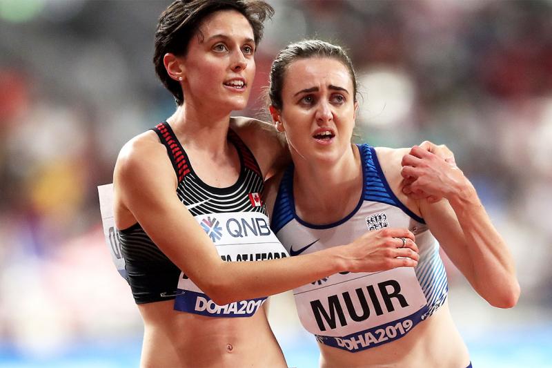 Gabriela Debues-Stafford and Laura Muir link arms nervously, looking upwards.