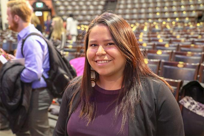 Diana Hill stands in the middle of Convocation Hall, smiling as sunlight falls on her