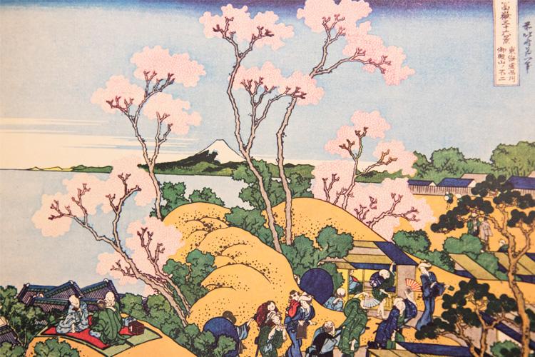 Painting of people picnicking on a hill in front of a sea of cherry blossoms in bloom, with Mount Fuji in the background.