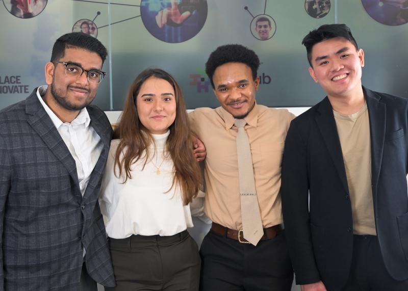  Joshua Raphael, Kritika Pandey, Didier Ramazani and Benny Liao smile, standing arm in arm.