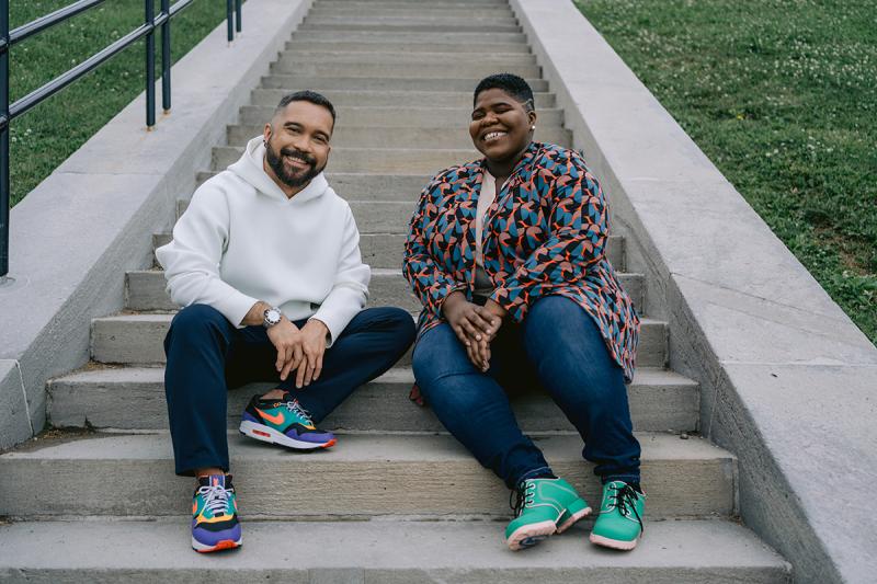 Michael Adia and Joelleann Forbes sitting together on staircase outside, smiling.