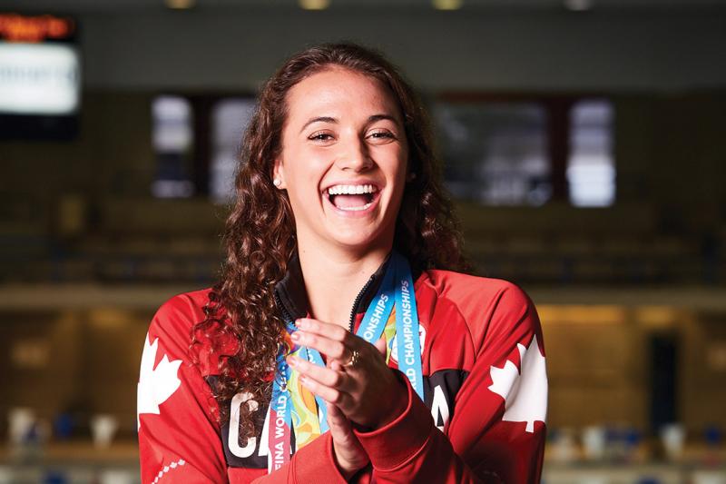 Kylie Masse laughs joyfully, wearing a Canada shirt.