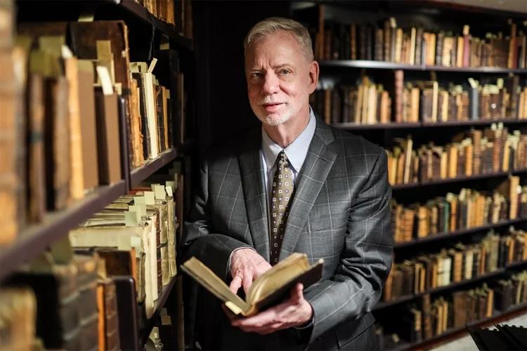 A man standing in the library stacks