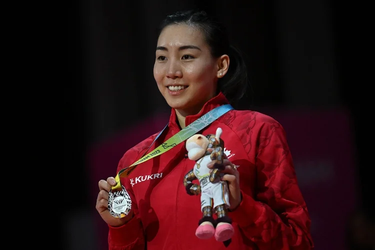 Michelle Li holds up a medal at a presentation ceremony