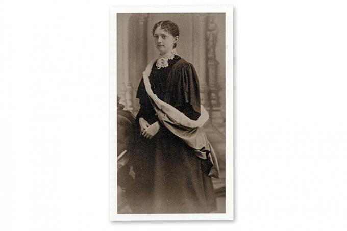 Photo of Nellie Greenwood in a lace-necked Victorian gown and an academic robe.