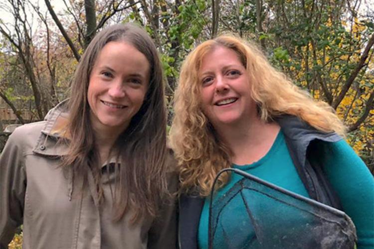 Rosalind Murray and Shannon McCauley smile near leafless trees outdoors.