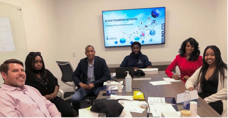 Jon French, Elsie Amoako, Craig Wellington, Efosa Obano, Gwyn Chapman and Ruth Mengitsu sit around a meeting table.