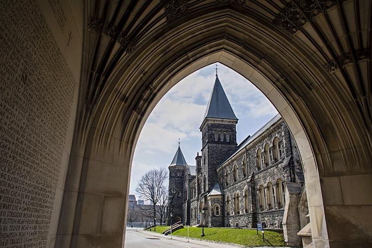 The towers of Hart House are framed in a stone archway.
