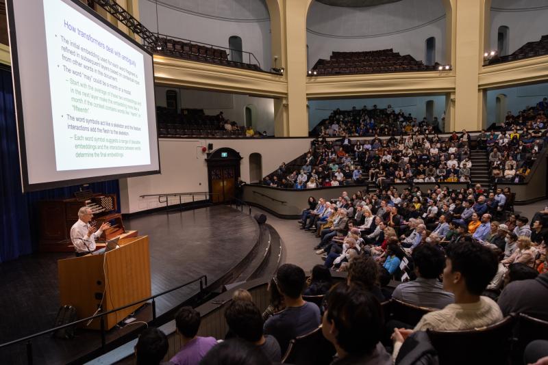 Geoffrey Hinton giving a talk on stage at Convocation Hall