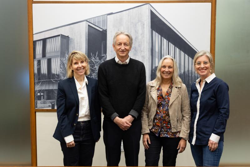 Geoffrey Hinton standing with three other people
