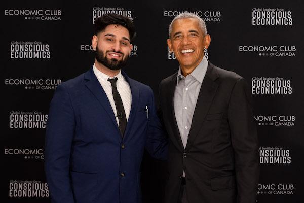 Wali Shah and Barack Obama, both smiling, stand together near a backdrop with logos of economic organizations.